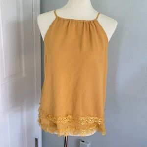 Yellow tank top from Altar’d state, brand is Alaya